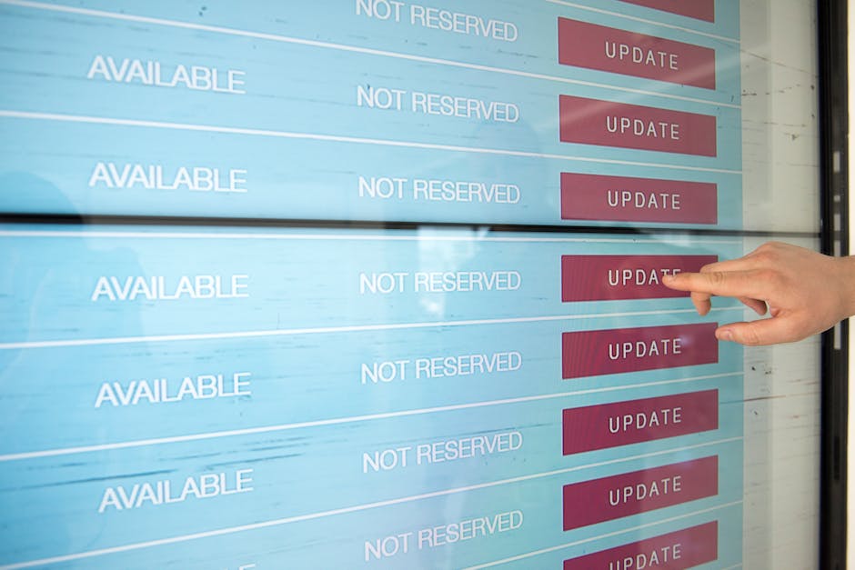 A person using their finger to press the 'update' button on a digital screen displaying a list of gardening service bookings, with the words 'AVAILABLE' and 'NOT RESERVED' visible alongside red 'UPDAT